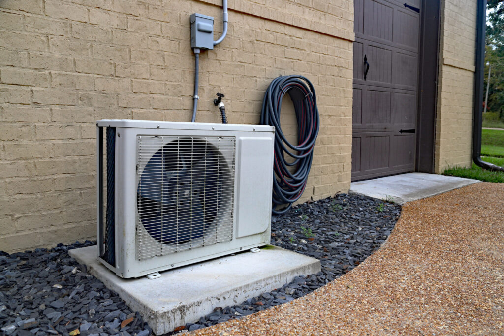 Air Conditioner mini split system next to home with brick wall